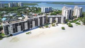 A coastal hotel with multiple high-rise buildings, a beachfront, and surrounding greenery. - Carlos Pointe 434 | 2BR/2BA, Renovated, Beachfront & pool (Fort Myers Beach)