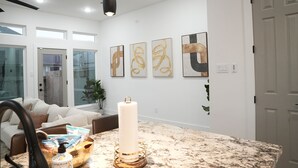 A modern living room with a marble countertop, a large white candle, and abstract wall art.