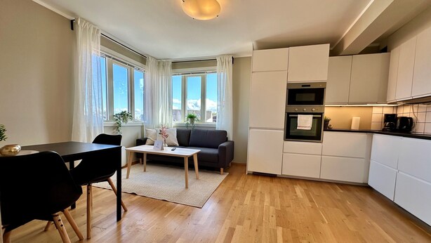 A modern kitchen with white cabinets, a built-in oven, and a coffee machine. - Forenom Serviced Apartments Stavanger (Stavanger)
