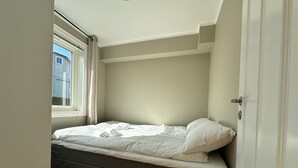 A room with a bed, a window with curtains, and a door. - Forenom Serviced Apartments Stavanger (Stavanger)