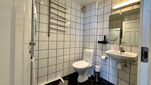 A bathroom with a toilet, sink, and mirror. - Forenom Serviced Apartments Stavanger (Stavanger)