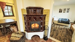 A room with a stone fireplace, a wooden bench, and a bed. - Rabštejn by Interhome (Zihle)