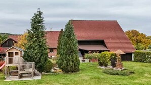 A house with a red roof, a wooden playhouse, and a well-maintained lawn. - Rabštejn by Interhome (Zihle)