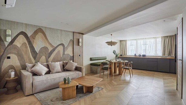 A modern living room with a sofa, coffee table, and a dining area with a table and chairs.
