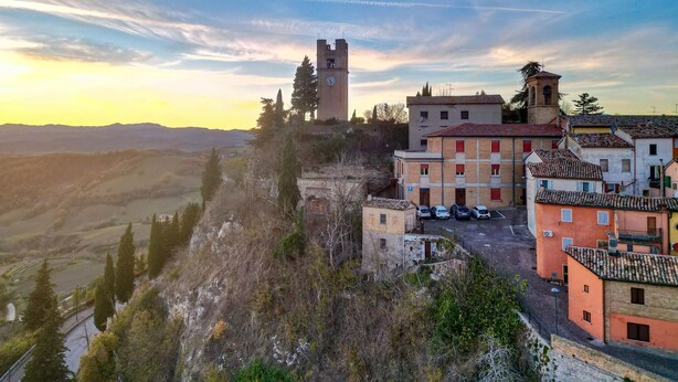 A historic town with a prominent clock tower, terraced buildings, and a scenic hillside view. - 3 bedroom awesome apartment in Peglio (Peglio)