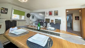 A dining area with a long wooden table set for four, surrounded by chairs. - Alexanders Domizil by Interhome (Schonach)