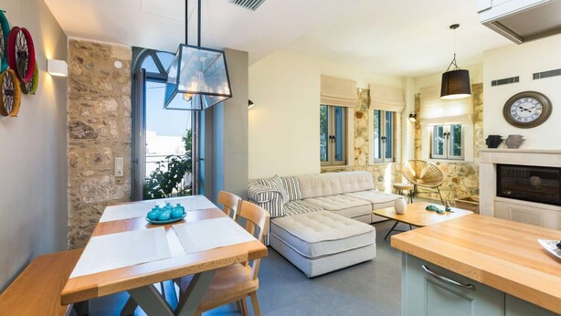 Een moderne woonkamer met een bank, een eettafel en een keukenhoek.