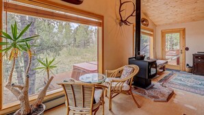 Una habitación acogedora con un ventanal grande, chimenea y zona de comedor.