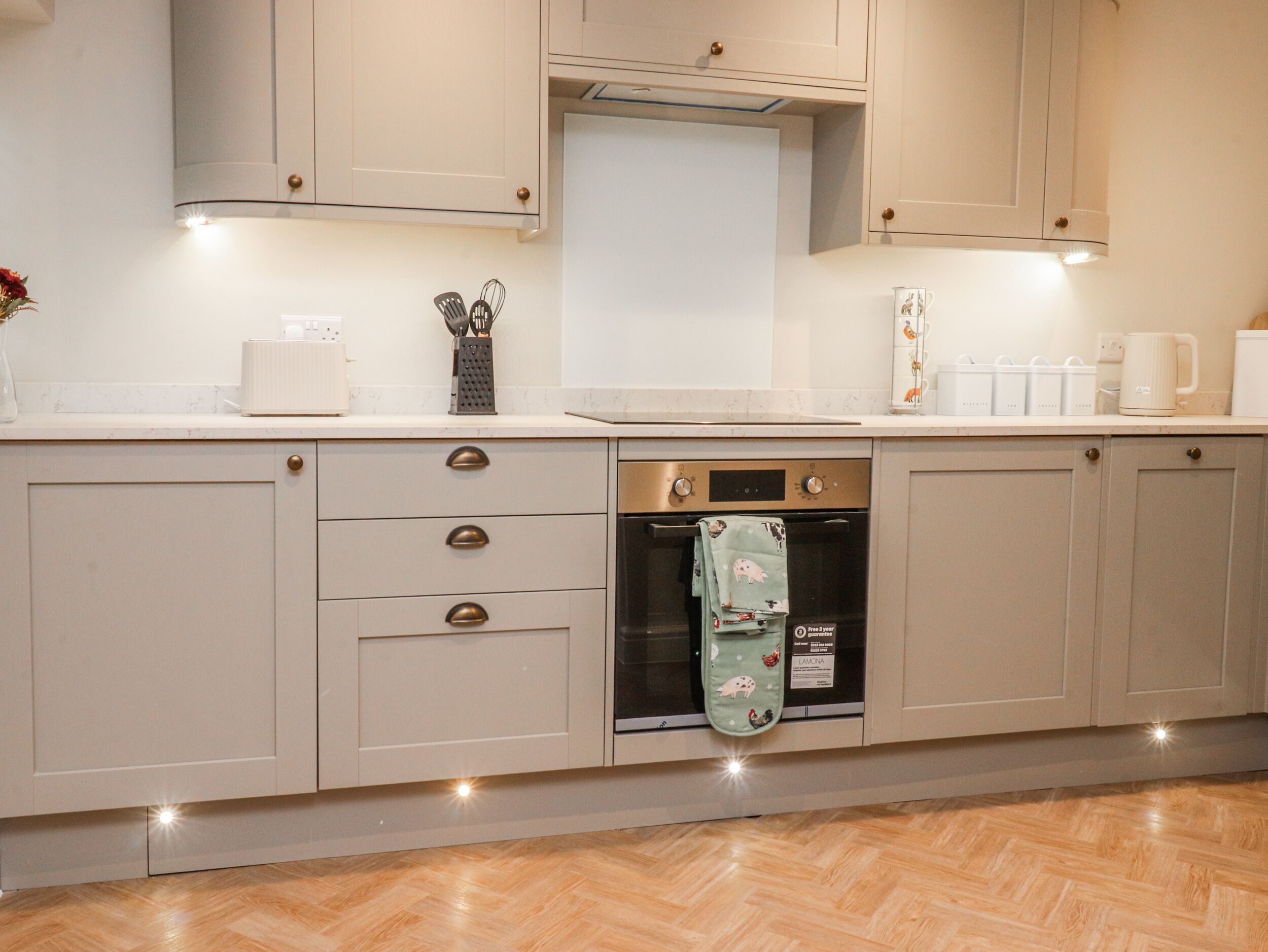 A kitchen with light-colored cabinets, a built-in oven, and a dishwasher.