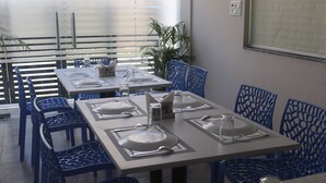 Comedor con sillas y mesas azules para cuatro personas.