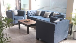 Un salón moderno con un conjunto de sofás, una mesa de centro y plantas en macetas.