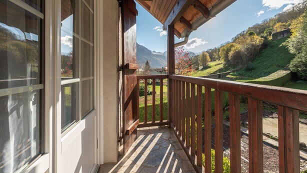 Un balcón de madera con vistas a un paisaje montañoso.