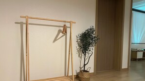 A wooden easel with a plant in a woven basket beside it. - Ondam Pension (Incheon)