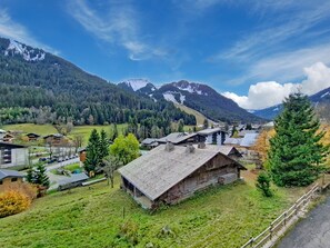 A rural village with traditional wooden houses, a road, and mountains in the background. - VOINETTES VNB7 SKI & MOUNTAIN (5 people) (Châtel)