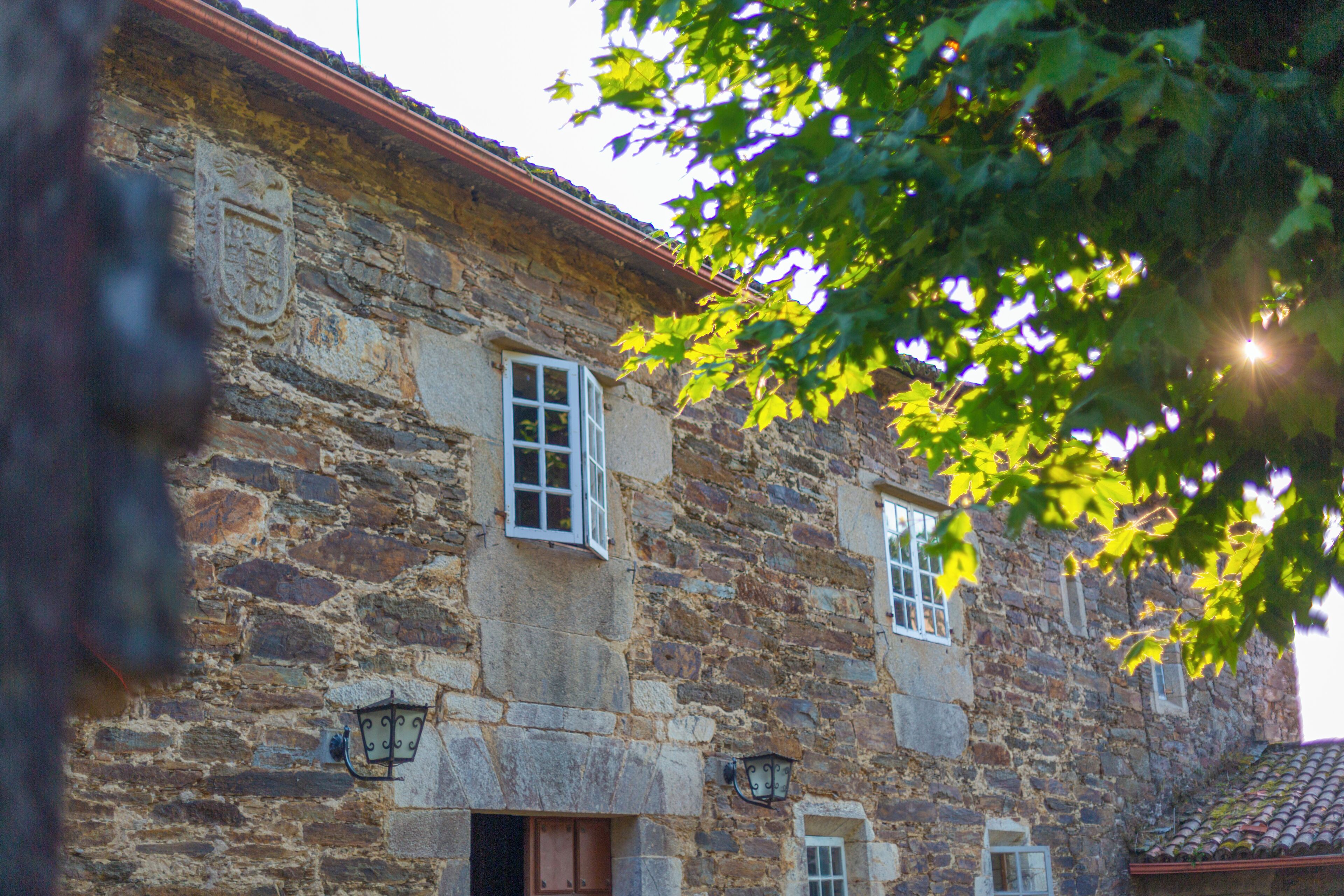 A stone building with two windows, a door, and a small balcony.