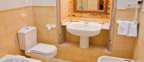 A bathroom with a toilet, sink, and bathtub.