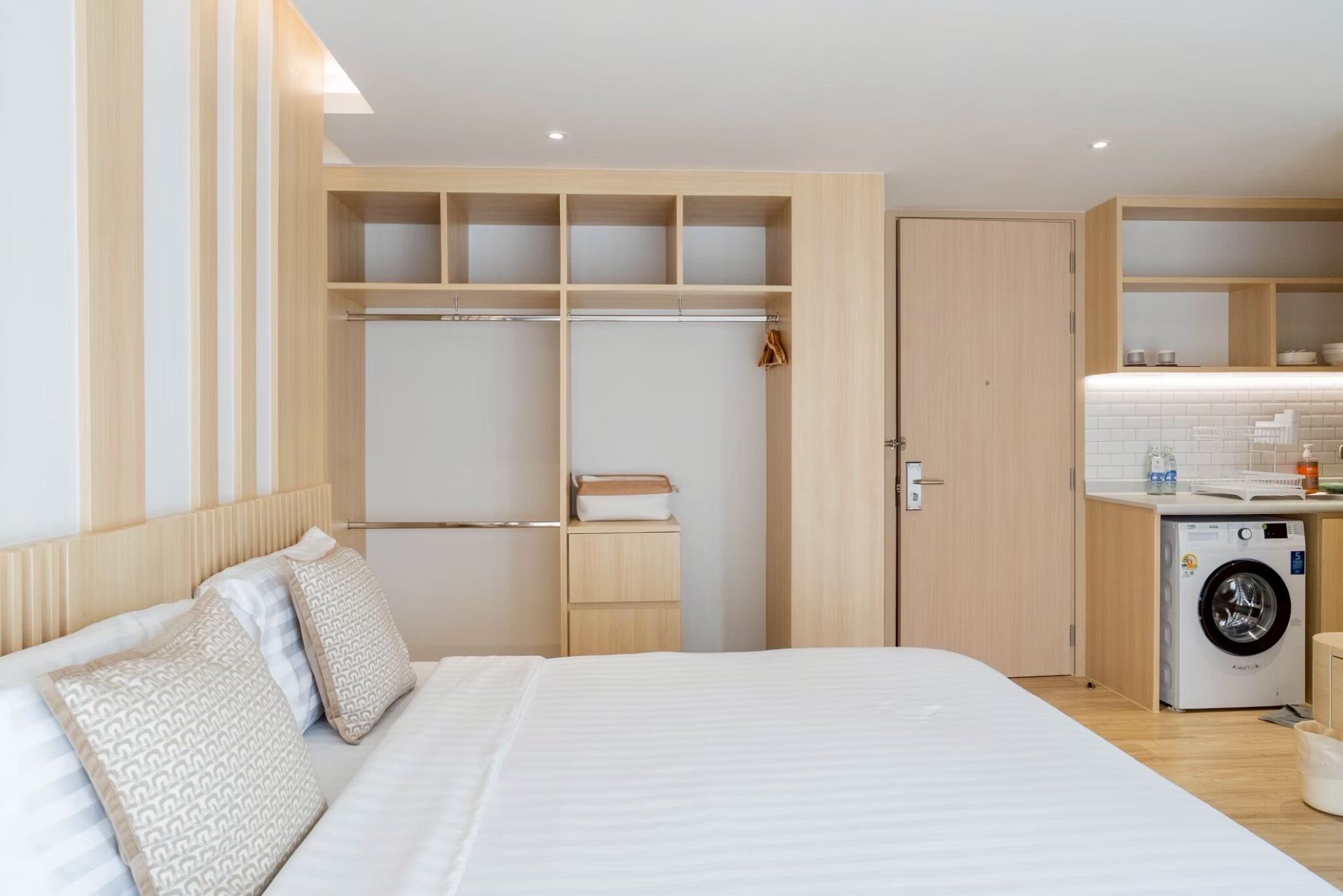 A bedroom with a bed, a wardrobe, and a washing machine.