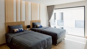 A modern hotel room with two beds, a large window, and a wooden floor. - I-Zen Residence Central Eastville (Bangkok)
