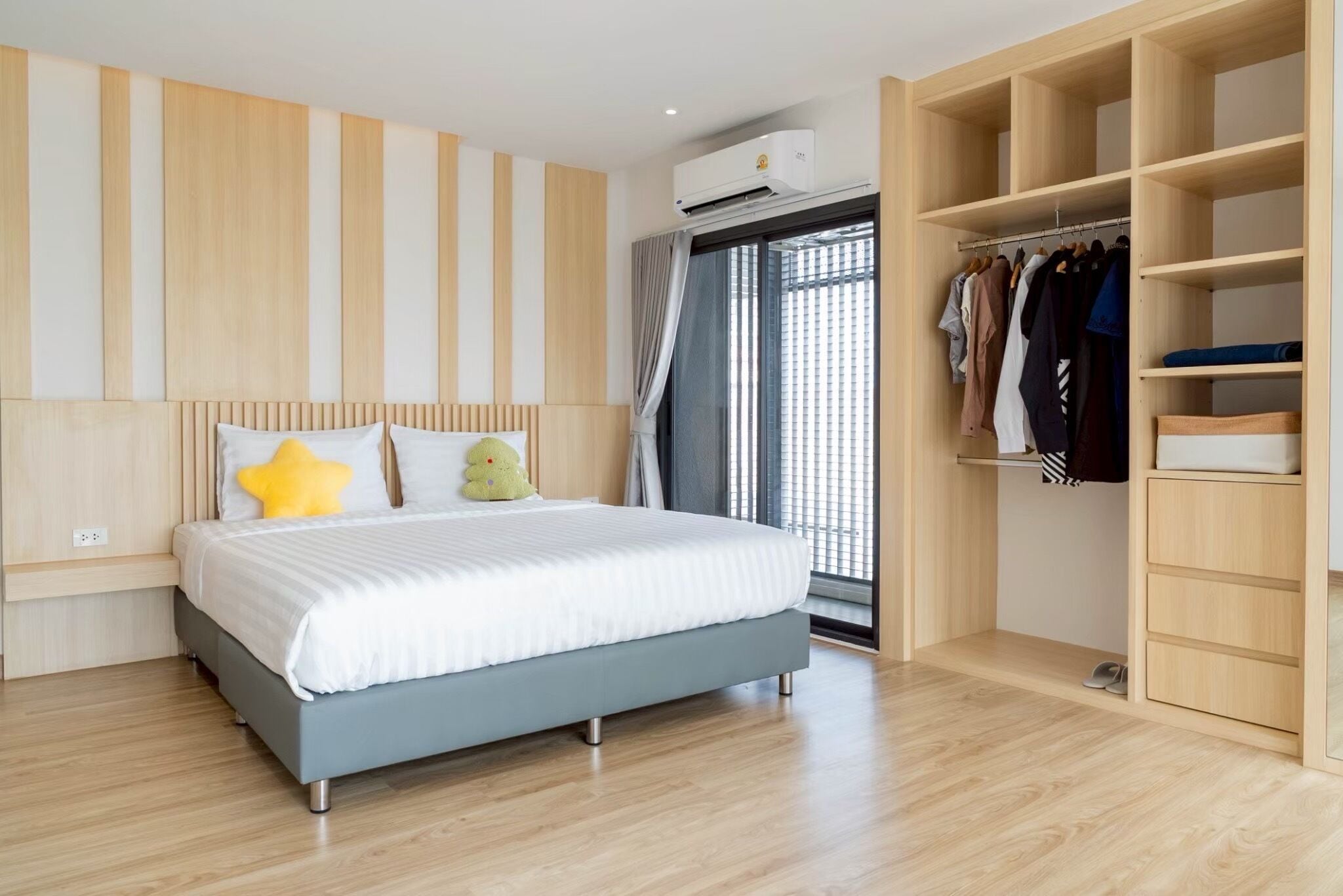 Un dormitorio moderno con cama, armario y ventana con persianas.
