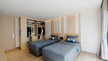 A bedroom with two beds, a wardrobe, and a mirror.