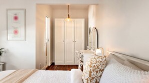 Ein Schlafzimmer mit Bett, Nachttisch, Lampe und Kleiderschrank.