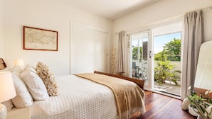 Un dormitorio con cama, un mapa en la pared y vista al exterior a través de una puerta corrediza.