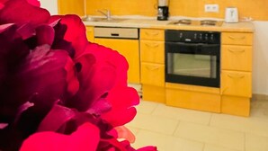 A kitchen with yellow cabinets, a microwave, a coffee maker, and an oven. - Stylish Studio Stay Near Augarten (Vienna)