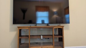 Un televisor de pantalla plana montado en un mueble de madera con estantes.