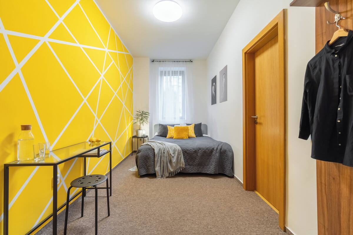 Ein Schlafzimmer mit Bett, Schreibtisch und Stuhl.