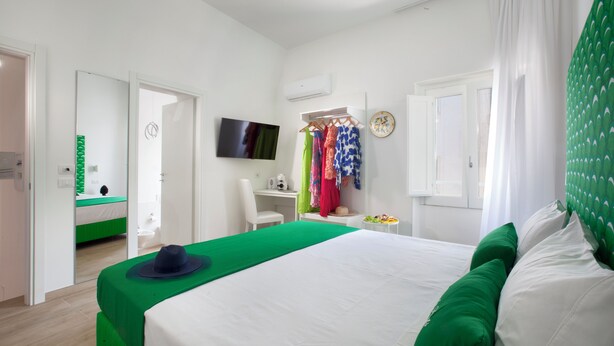 Una habitación de hotel con cama, televisión, escritorio y una silla.