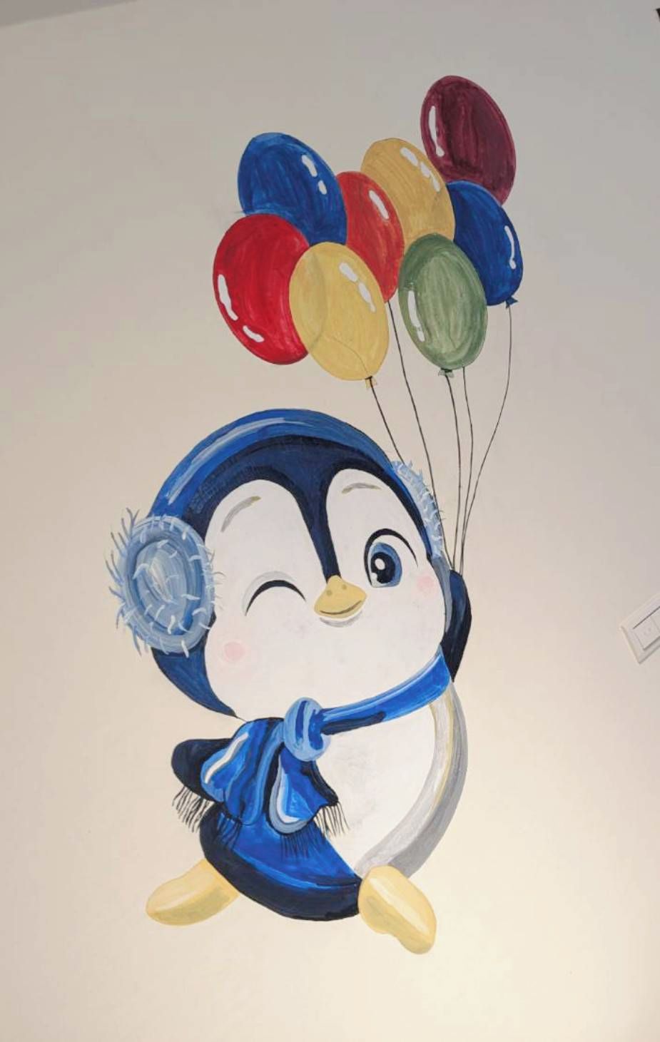 En pingvin med färgglada ballonger.