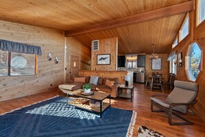 Ein gemütliches Holzhaus-Interieur mit Wohnbereich, Essbereich und Küche.