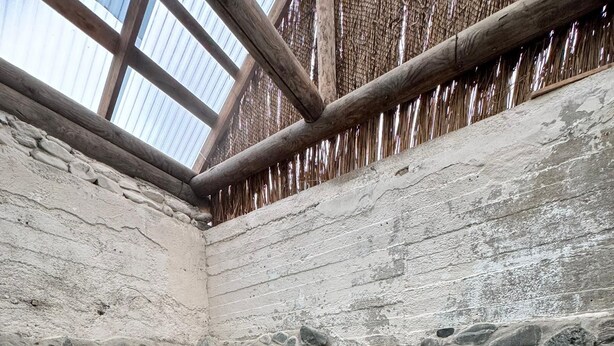 A stone-walled hot spring with clear water, a wooden ceiling, and a stone wall with a thatched roof. - Arashan Hotel (Teploklyuchenka)