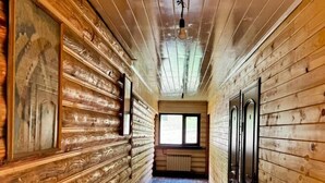 A narrow hallway with wooden walls and a radiator on the right. - Arashan Hotel (Teploklyuchenka)