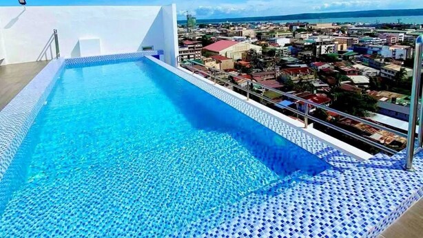 Une piscine sur le toit offrant une vue dégagée sur le paysage urbain en arrière-plan.