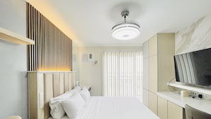 Une chambre d’hôtel moderne équipée d’un lit, d’une télévision, d’un bureau et d’une chaise.