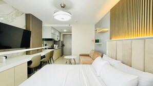 Une chambre d’hôtel équipée d’un lit, d’un bureau, d’une chaise, d’un canapé et d’une télévision.