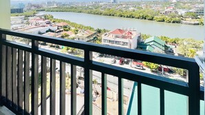 Un balcon donnant sur une rivière et sur des bâtiments situés au loin.