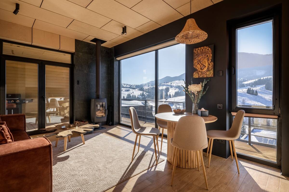 Un salon moderne avec une grande fenêtre, une table de salle à manger ronde et un canapé.