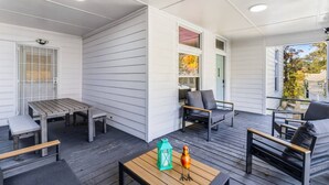 A covered outdoor patio with a wooden table, chairs, and a bench. - 6BR Gem in Midtown Atlanta (Atlanta)