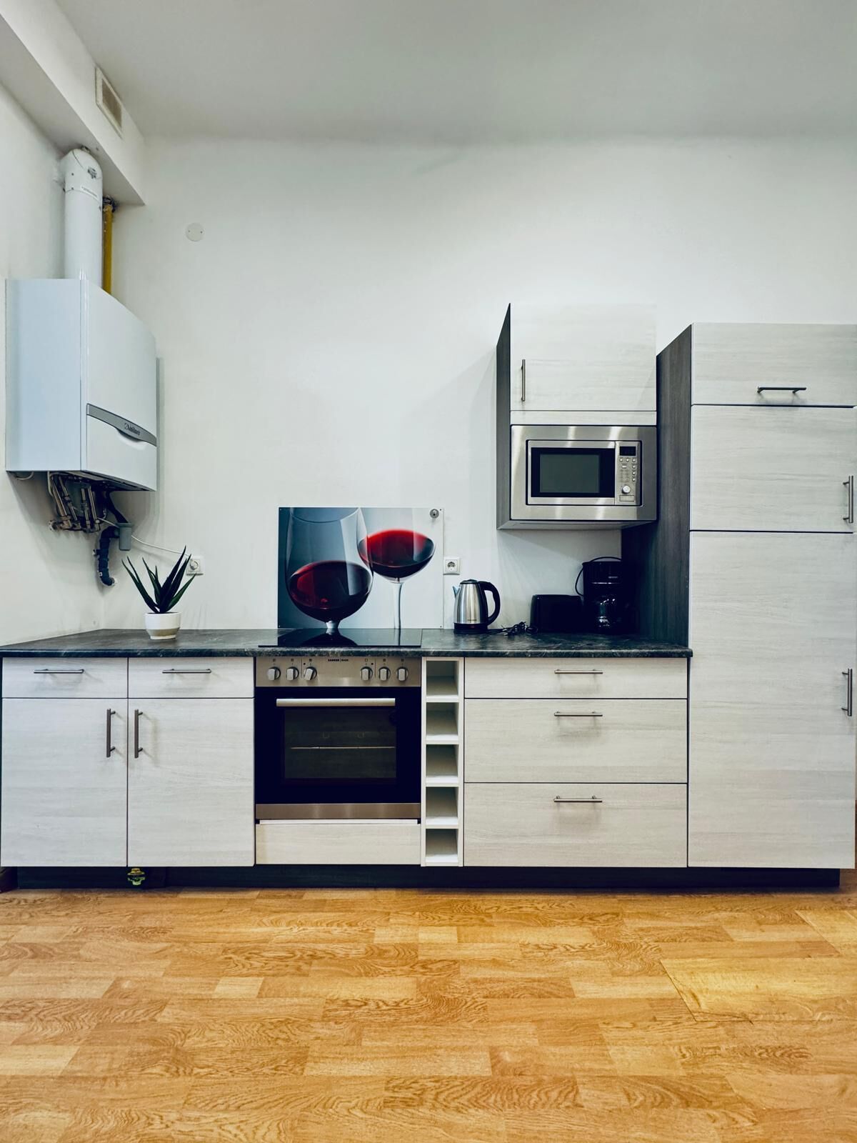 A modern kitchen with stainless steel appliances, a built-in oven, and a microwave.