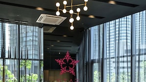 A modern interior with a large window, a sofa, and two armchairs. - STAR KLCC By Super Suites  (Kuala Lumpur)