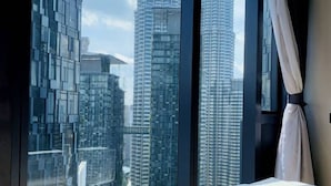 A bedroom with a large window offering a city skyline view. - STAR KLCC By Super Suites  (Kuala Lumpur)