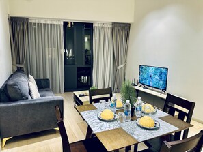 Luxe appartement, 2 slaapkamers, niet-roken, uitzicht op de stad | Woonruimte | Een 56-inch ledtelevisie met digitale zenders en een open haard