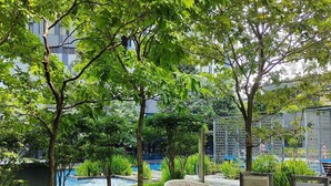 A lush garden area with a pool, a seating area, and informational signs. - STAR KLCC By Super Suites  (Kuala Lumpur)