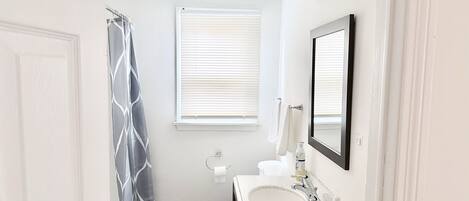 Une salle de bain avec des toilettes, un lavabo et un rideau de douche.