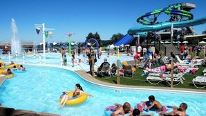 A water park with a pool, inflatable rides, and a water slide.