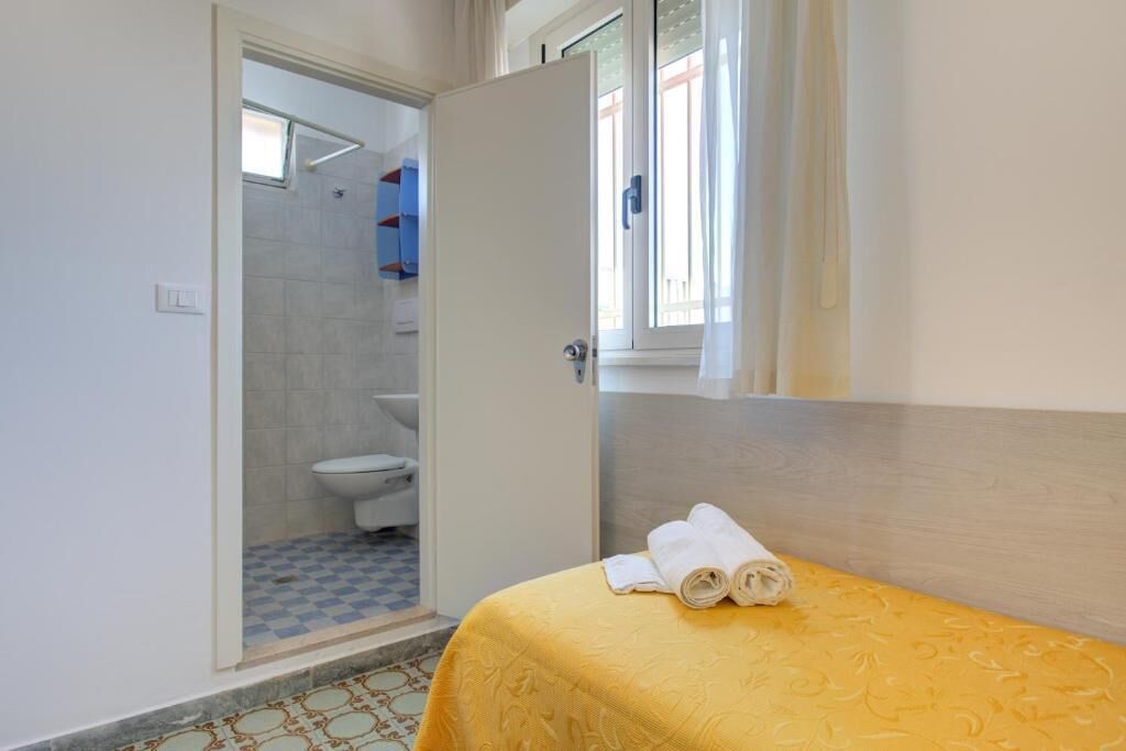 Ein Zimmer mit einem Bett, einem Badezimmer mit Toilette und einer Duschkabine.