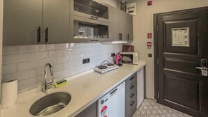 A compact kitchen with a sink, a microwave, and a dishwashing machine. - Balatside Family Suite (İstanbul)