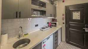 Uma cozinha moderna com pia, micro-ondas, torradeira e máquina de lavar louça.